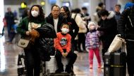 Travellers wearing protective masks arrive at the Beijing Capital Airport in Beijing on January 21, 2020. AFP / NOEL CELIS