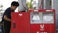 An employee of Japan Post Co collects mail at a post office in Tokyo October 26, 2012. Reuters/Toru Hanai 