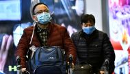 Travellers, wearing masks, arrive on a direct flight from China, after Canada's Public Health Agency added a screening question for visitors and began displaying messages in several airports urging travellers to report flu-like symptoms in efforts to prev