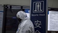 Security personnel wearing protective clothing to help stop the spread of a deadly virus which began in Wuhan, stands at a subway station in Beijing on January 26, 2020. AFP / NOEL CELIS