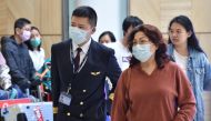 A China Eastern Airlines pilot and passangers arrive at Sydney airport after landing a plane from Shanghai on January 25, 2020. Australian authorities confirmed its first case of a new virus as thousands of people worldwide are treated for the deadly infe