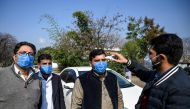 An official of Pakistan-based Chinese company (R) uses a thermo gun to check the temperature of the company's drivers, in Islamabad on January 30, 2020, after instructions from Pakistani authorities to take preventive measures against the coronavirus. A v
