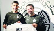 Al Sadd's defender Tareq Salman holds a team jersey with coach Xavi Hernandez at the Al Sadd Club yesterday after the club announced that the Qatari international's contract has been extended until the 2024 season.