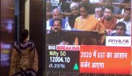 A woman stands as she watches a screen displaying a television channel live broadcast of India's Finance Minister Nirmala Sitharaman (C on screen) presenting the 2020 union budget, at the Bombay Stock Market (BSE) in Mumbai on February 1, 2020. (AFP / Pun