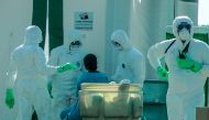 A Sri Lankan student (C) who was evacuated from the Chinese city of Wuhan is checked by medical staff wearing protective gear at Mattala Rajapaksa International Airport in Mattala on February 1, 2020.  AFP