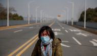 A mother reacts as she pleads with police to allow her daughter to pass a checkpoint for cancer treatment after she arrived from Hubei province at the Jiujiang Yangtze River Bridge in Jiujiang, Jiangxi province, China, as the country is hit by an outbreak
