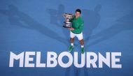 Serbia's Novak Djokovic holds the Norman Brooks Challenge Cup trophy after winning against Austria's Dominic Thiem in their men's singles final match on day fourteen of the Australian Open tennis tournament in Melbourne on February 3, 2020. (AFP / DAVID G