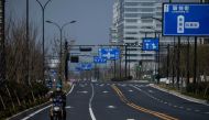 A lone motorcycle rider is seen on an empty street in Hangzhou, some 175 kilometres (110 miles) southwest of Shanghai on February 5, 2020, near the Alibaba headquarters.  AFP / NOEL CELIS