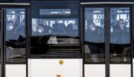 Italian citizens repatriated from the coronavirus hot-zone of Wuhan are transfered by bus after landing at the Mario De Bernardi military airport in Pratica di Mare, south of Rome, on February 3, 2020 prior to be placed in quarantine at the nearby Cecchig
