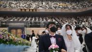 Couples wearing protective face masks attend a mass wedding ceremony organised by the Unification Church at Cheongshim Peace World Center in Gapyeong, South Korea, on February 7, 2020. AFP / Jung Yeon-je
 
