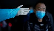 A passenger wearing a mask walk outside the Shanghai railway station in Shanghai, China, as the country is hit by an outbreak of the new coronavirus, February 8, 2020. REUTERS/Aly Song