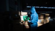 A staff member carrying a box of medical supplies from Pakistan at a warehouse of an exhibition centre which has been converted into a makeshift hospital in Wuhan, the epicentre of the new coronavirus outbreak, in China's central Hubei province on Februar