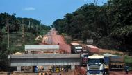 Trucks drive along the Trans-Amazonian highway BR230 past a bridge under construction, near Ruropolis, Para state, Brazil, in the Amazon rainforest, on September 7, 2019. AFP / Nelson Almeida