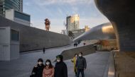In a photo taken on February 11, 2020 people wearing face masks walk through Dongdaemun Design Plaza in Seoul. / AFP / Ed JONES 