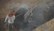 A boy shovels smoldering ash out of a kiln at a brick factory in Kandal Province, Cambodia, on January 23, 2020. Thomson Reuters Foundation/Matt Blomberg