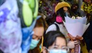 A man wearing a protective face mask as a preventative measure against the COVID-19 coronavirus, buys flowers to mark Valentine's Day in Hong Kong on February 14, 2020. / AFP / Philip Fong