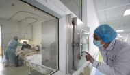 FILE PHOTO: A medical worker calls his colleague inside an isolated ward at Jinyintan Hospital in Wuhan, the epicentre of the novel coronavirus outbreak, in Hubei province, China February 13, 2020. 