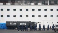 Japan Self-Defense Forces members walk past a military vehicle attached to a gate of the Diamond Princess cruise ship, which has around 3,600 people quarantined onboard due to fears of the new COVID-19 coronavirus, at the Daikoku Pier Cruise Terminal in Y