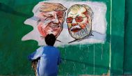  A man applies finishing touches to paintings of U.S. President Donald Trump and India's Prime Minister Narendra Modi on a wall as part of a beautification along a route that Trump and Modi will be taking during Trump's upcoming visit, in Ahmedabad, India