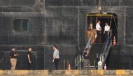 People stand near by the Westerdam cruise ship in Sihanoukville on February 18, 2020, where the liner on February 13 docked after being refused entry at other Asian ports due to fears of the novel coronavirus. A scramble intensified February 17 to trace p