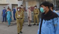  Security personnel (C) and hospital staff wearing facemasks stand outside an hospital entrance in Karachi on February 17, 2020, after a gas leak killed five people and sickened dozens of others in a coastal residential area in Pakistan's port city of Kar