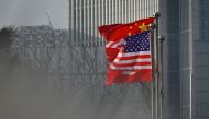 (FILES) In this file photo taken on January 19, 2020, Chinese and US national flags flutter at the entrance of a company office building in Beijing.  AFP / WANG ZHAO