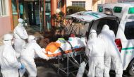 Medical workers wearing protective gear transfer a suspected coronavirus patient (C) to another hospital from Daenam Hospital where a total of 16 infections have now been identified with the COVID-19 coronavirus, in Cheongdo county near the southeastern c