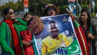  Spectators carry a poster featuring an image of Peshawar Zalmi's team captain Darren Sammy outside the National Cricket Stadium in Karachi on February 21, 2020, ahead of the start of the Pakistan Super League (PSL) T20 cricket match between Peshawar Zalm