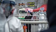 This photo taken on February 22, 2020 shows a woman welcoming people who have recovered from the COVID-19 coronavirus infection as they are discharged from the hospital in Wuhan in China's central Hubei province. China OUT / AFP / STR