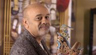 French shoe designer Christian Louboutin poses with one of his creations during a photo session at the Palais de la Porte Doree in Paris a few days before the opening of his exhibition 