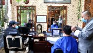 An employee wearing a face mask cuts hair for a customer at a traditional barber shop in Beijing, China February 24, 2020. China Daily via Reuters