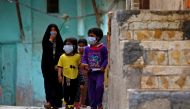 Iraqi children wear protective masks as they walk near a religious school where the first coronavirus case was detected, following the outbreak of the new coronavirus, in the holy city of Najaf, Iraq February 24, 2020. Reuters/Alaa al-Marjani