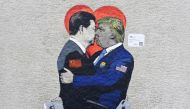 ‘Smart Love’ mural by Italien street artist TvBoy depicts Xi Jinping, holding an i-Phone smartphone kissing US President Donald Trump, holding an Huawei smartphone in Milan on June 29, 2019. AFP / Miguel Medina