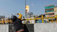 A man supporting a new citizenship law throws a petrol bomb at a Muslim shrine during a clash with those opposing the law in New Delhi India, February 24, 2020. Reuters/Danish Siddiqui
 
