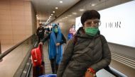 A passenger wearing a protective face mask and glasses arrives at Pudong International Airport in Shanghai, on February 24, 2020. AFP / Hector Retamal