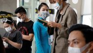  A ground staff member of Vietnam Airlines and passengers wearing protective mask, following an outbreak of the novel coronavirus, wait for boarding at the Danang airport in Danang city, Vietnam February 23, 2020. REUTERS/Kham 