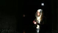 A woman holds a candle in Svetitshoveli Cathedral, an Orthodox Christian cathedral located in the historic town of Mtskheta, in Tbilisi, Georgia on February 19, 2020. (Özkan Bilgin / Anadolu Agency)
 