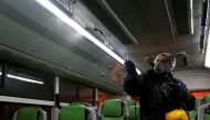 A Tehran Municipality worker cleans a bus to avoid the spread of the COVID-19 illness on February 26, 2020. AFP / ATTA KENARE