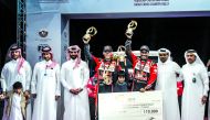 Nasser Saleh Al Attiyah (third right) and his French co-driver Matthieu Baumel lift their trophies in the presence of QMMF President, Abdul Rahman Al Mannai yesterday.  