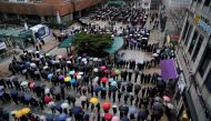 People wearing masks after the coronavirus outbreak wait in a line to buy masks as it rains in front of a department store in Seoul, South Korea, February 28, 2020. REUTERS/Kim Hong-Ji