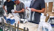 Employees pack respiratory protective face masks on an assembly line at the Valmy manufacturer plant in Mably, central France, on February 28, 2020, amid the spread of coronavirus.  AFP / Philippe Desmazes 