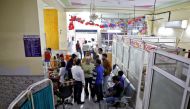 Staff members and volunteers speak in a lobby of Al-Hind hospital, where victims are treated and many have taken shelter after they fled their homes following clashes between people demonstrating for and against a new citizenship law in a riot affected ar