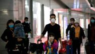 This photo taken on February 28, 2020 shows passengers wearing face masks arriving at Wenzhou railway station in Wenzhou. The National Health Commission on March 1 reported 573 new infections, bringing the total number of cases in mainland China to 79,824