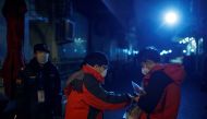  A guard checks the temperature of a man at a checkpoint to a hutong neighbourhood in Beijing as the country is hit by an outbreak of the novel coronavirus, China, February 26, 2020. REUTERS/Thomas Peter 