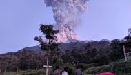 Tourists look towards Mount Merapi volcano as it erupts, at Cangkringan district in Sleman, Yogyakarta, Indonesia March 3, 2020 in this photo taken by Antara Foto. Antara Foto/Rizky Tulus/ via REUTERS