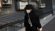 A woman wears a face mask as she walks in a street in Beijing as the country is hit by an outbreak of the novel coronavirus, China, March 4, 2020. REUTERS/Thomas Peter