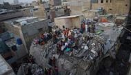  Pakistani volunteer moves the body of a victim from the rubble of a collapsed five-storey residential building in Karachi on March 5, 2020. / AFP / Asif HASSAN
