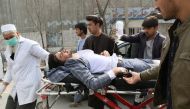 An injured man is brought on a stretcher to an ambulance following a gun attack during an event to mark the 25th anniversary of death of Shiite leader Abdul Ali Mazari, In Kabul on March 6, 2020. AFP / STR