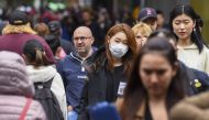 A woman wearing a face mask crosses the street in Melbourne on March 5, 2020. Over 50 people have been confirmed to have the COVID-19 coronavirus in Australia so far with the latest cases including an eight-month-old baby in Adelaide. / AFP / William WEST