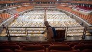 A staff member sprays disinfectant after the final patients were discharged at a temporary hospital set up to treat people with the COVID-19 coronavirus in a sports stadium in Wuhan, in China's central Hubei province on March 8, 2020.  / AFP / STR AND STR
